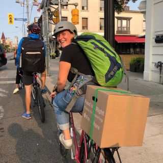 person on a bike wearing a helmut looking behind them smiling